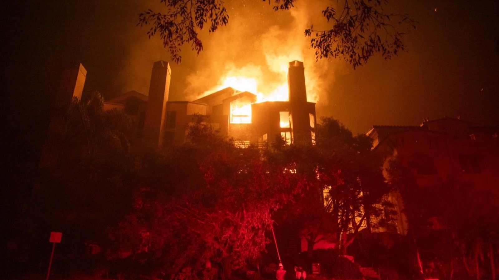 California home engulfed in wildfire flames at night